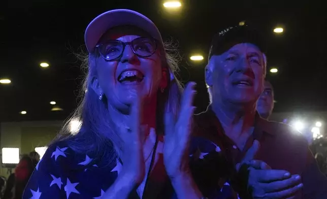 ADDS NAMES - Bonny Dyer, left, and her husband Larry Dyer, supporters of Republican presidential nominee former President Donald Trump, react as he speaks at an election night watch party, Wednesday, Nov. 6, 2024, in West Palm Beach, Fla. (AP Photo/Marta Lavandier)