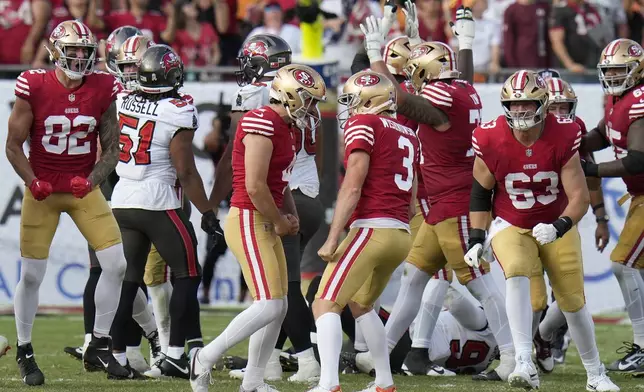 San Francisco 49ers place kicker Jake Moody, middle left, celebrates with Mitch Wishnowsky (3) and teammates after kicking the game winning field goal during the second half of an NFL football game against the Tampa Bay Buccaneers in Tampa, Fla., Sunday, Nov. 10, 2024. (AP Photo/Chris O'Meara)