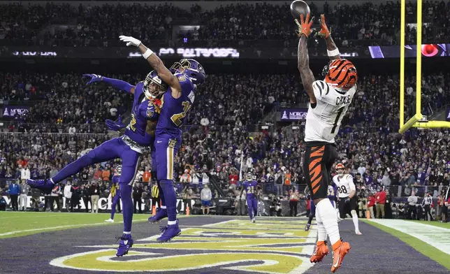 Cincinnati Bengals wide receiver Ja'Marr Chase (1) catches a touchdown pass over Baltimore Ravens cornerback Nate Wiggins (2) and safety Ar'Darius Washington (29) during the second half of an NFL football game, Thursday, Nov. 7, 2024, in Baltimore. The Ravens won 35-34. (AP Photo/Nick Wass)