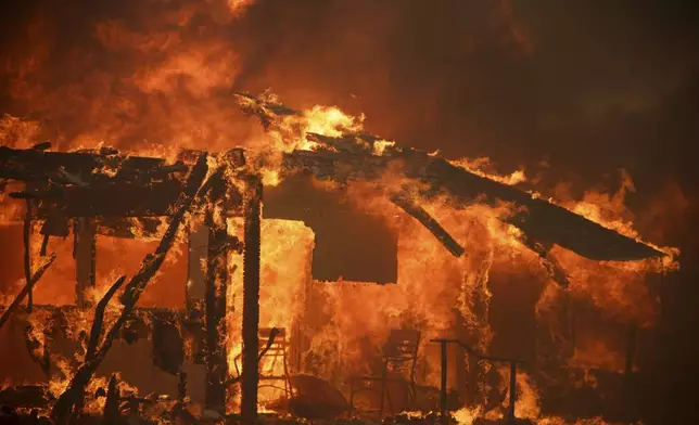 Flames engulf a structure during the Mountain Fire, Wednesday, Nov. 6, 2024, near Camarillo, Calif. (AP Photo/Ethan Swope)