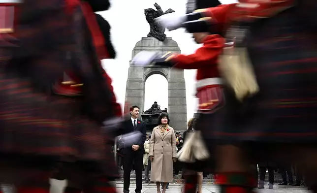 Canadian Prime Minister Justin Trudeau, center left, and Minister of Veterans Affairs and Associate Minister of National Defence Ginette Petitpas Taylor watch as Canadian Forces members march off to conclude the Remembrance Day ceremony at the National War Memorial in Ottawa, Ontario, Monday, Nov. 11, 2024. (Justin Tang/The Canadian Press via AP)