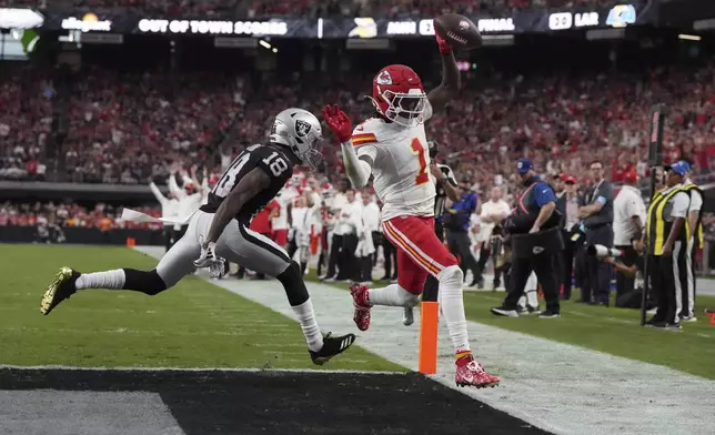 Kansas City Chiefs wide receiver Xavier Worthy (1) scores past Las Vegas Raiders cornerback Jack Jones (18) during the second half of an NFL football game Sunday, Oct. 27, 2024, in Las Vegas. (AP Photo/Rick Scuteri)