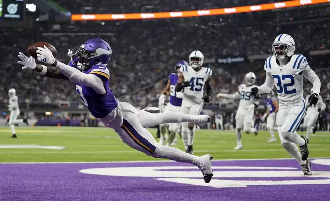 Minnesota Vikings wide receiver Jordan Addison (3) catches a 4-yard touchdown pass ahead of Indianapolis Colts safety Julian Blackmon (32) during the second half of an NFL football game, Sunday, Nov. 3, 2024, in Minneapolis. (AP Photo/Abbie Parr)