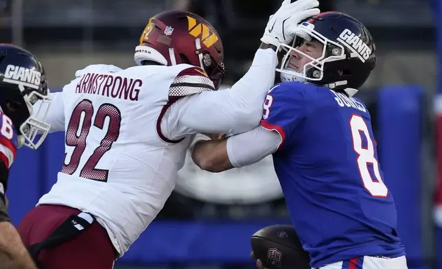 Washington Commanders defensive end Dorance Armstrong (92) sacks New York Giants quarterback Daniel Jones (8) during the third quarter of an NFL football game, Sunday, Nov. 3, 2024, in East Rutherford, N.J. (AP Photo/Seth Wenig)