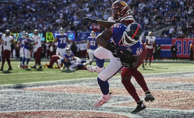 New York Giants tight end Chris Manhertz (85) makes a touchdown catch against Washington Commanders safety Percy Butler (35) during the second quarter of an NFL football game, Sunday, Nov. 3, 2024, in East Rutherford, N.J. (AP Photo/Seth Wenig)