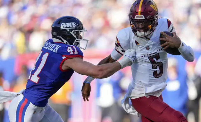 Washington Commanders quarterback Jayden Daniels (5) carries the ball against New York Giants linebacker Micah McFadden (41) during the second quarter of an NFL football game, Sunday, Nov. 3, 2024, in East Rutherford, N.J. (AP Photo/Seth Wenig)