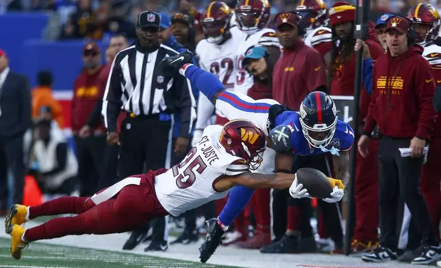 New York Giants wide receiver Malik Nabers (1) dives for a pass against Washington Commanders cornerback Benjamin St-Juste (25) during the fourth quarter of an NFL football game, Sunday, Nov. 3, 2024, in East Rutherford, N.J. (AP Photo/John Munson)