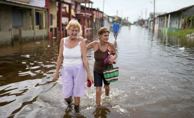 Residents wade through a flooded street after the passing of Hurricane Rafael in Batabano, Cuba, Thursday, Nov. 7, 2024. (AP Photo/Ramon Espinosa)