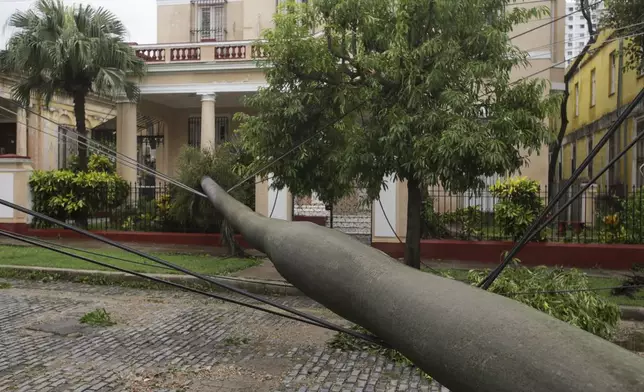 A fallen palm tree is held by the power lines it brought down after Hurricane Rafael passed through Havana, Cuba, Thursday, Nov. 7, 2024. (AP Photo/Ariel Ley)