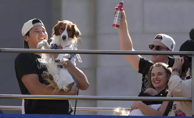 Los Angeles Dodgers' Shohei Ohtani holds his dog Decoy during the Los Angeles Dodgers baseball World Series championship parade Friday, Nov. 1, 2024, in Los Angeles. (AP Photo/Jae C. Hong)