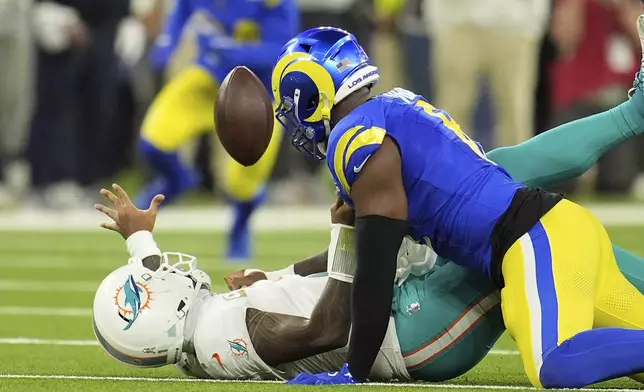 Los Angeles Rams linebacker Jared Verse, right, forces a fumble on Miami Dolphins quarterback Tua Tagovailoa during the first half of an NFL football game, Monday, Nov. 11, 2024, in Inglewood, Calif. The Rams recovered the ball. (AP Photo/Marcio Jose Sanchez)