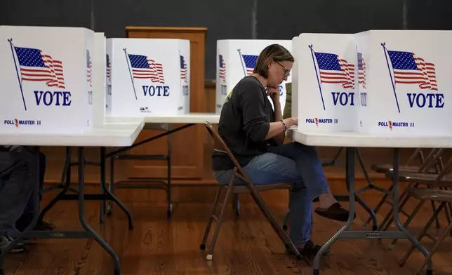 Kristin Scruggs votes at the 146-year-old Buck Creek school Tuesday, Nov. 5, 2024, in rural Perry, Kan. (AP Photo/Charlie Riedel)