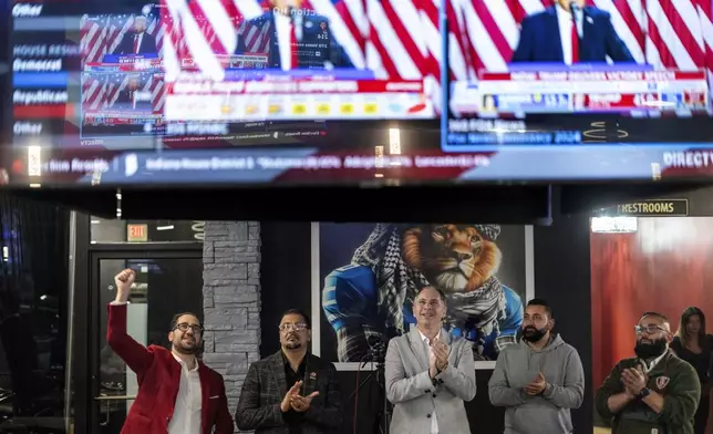 From left to right, Paul Manni, Sam Alasri, Wasel Yousaf, Waseem Makani and Abrahim Tamimi, cheer as former President Donald Trump's speech is broadcast during an Arab Americans for Trump watch party at the Lava Java Cafe, a hookah lounge, in the early hours of Wednesday, Nov. 6, 2024, in Dearborn, Mich. (AP Photo/David Goldman)