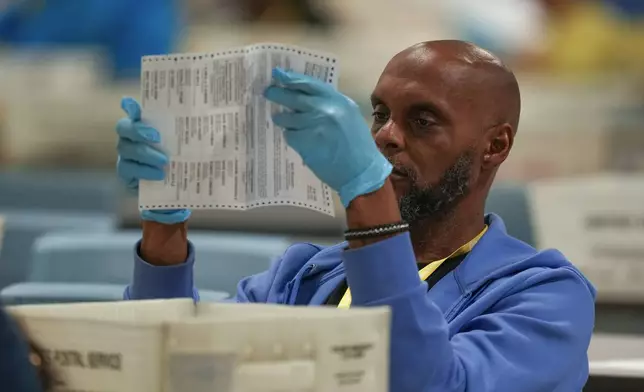 An election worker processes mail-in ballots for the 2024 General Election at the Philadelphia Election Warehouse, Tuesday, Nov. 5, 2024, in Philadelphia. (AP Photo/Matt Slocum)