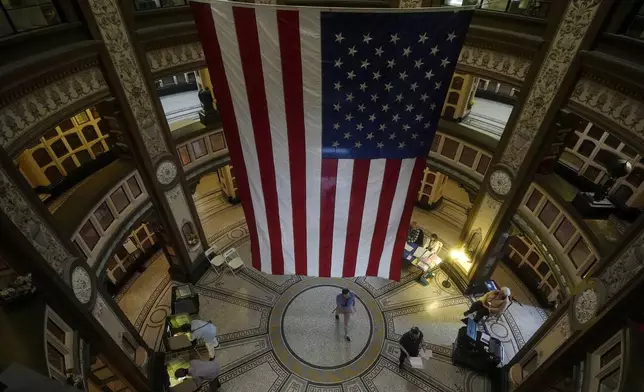 A large flag hangs from the ceiling as people vote at the San Francisco Columbarium &amp; Funeral Home in San Francisco on Election Day, Tuesday, Nov. 5, 2024. (AP Photo/Jeff Chiu)