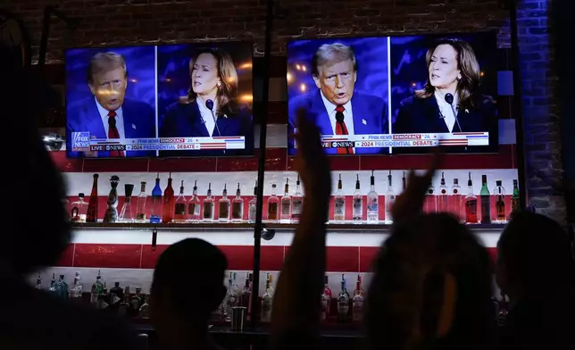 Viewers cheer as they watch a debate between Democratic presidential nominee Vice President Kamala Harris and Republican presidential nominee former President Donald Trump at the Angry Elephant Bar and Grill, Tuesday, Sept. 10, 2024, in San Antonio. (AP Photo/Eric Gay)