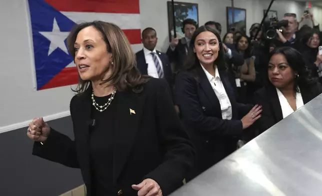 Democratic presidential nominee Vice President Kamala Harris, from left, visits Old San Juan Cafe restaurant with Rep. Alexandria Ocasio-Cortez, D-N.Y., and restaurant owner Diana de La Rosa during a campaign stop in Reading, Pa., Monday, Nov. 4, 2024. (AP Photo/Jacquelyn Martin)