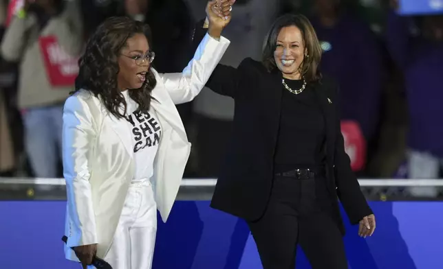 Oprah Winfrey holds hands with Democratic presidential nominee Vice President Kamala Harris after introducing Harris to speak during a campaign rally outside the Philadelphia Museum of Art, Monday, Nov. 4, 2024, in Philadelphia. (AP Photo/Matt Slocum)