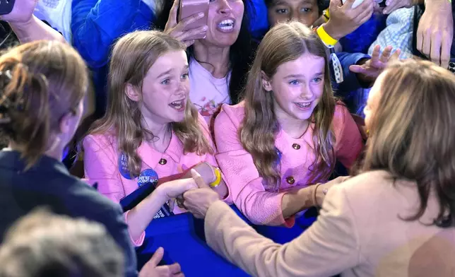 Democratic presidential nominee Vice President Kamala Harris, bottom right, greets young supporters after speaking during a campaign rally, Saturday, Nov. 2, 2024, at the PNC Music Pavilion in Charlotte, N.C. (AP Photo/Jacquelyn Martin)