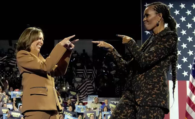 Democratic presidential nominee Vice President Kamala Harris, left, and former first lady Michelle Obama arrive to speak during a campaign rally at the Wings Event Center in Kalamazoo, Mich. (AP Photo/Jacquelyn Martin)