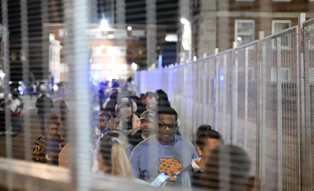 Attendees of Vice President Kamala Harris' presidential rally enter the venue at Howard University in a secure gated entrance, Tuesday, Nov. 5, 2024, in Washington. (AP Photo/Terrance Williams)