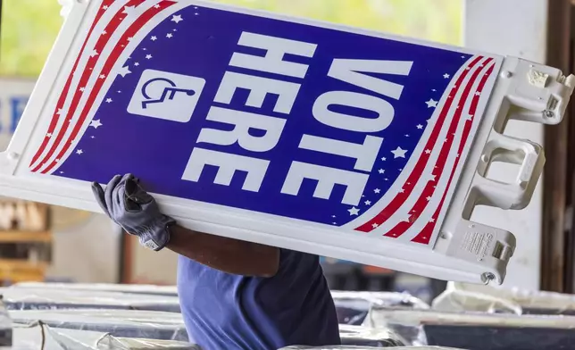 Voting machines and signs are loaded onto trucks from a warehouse in New Orleans East for delivery across the parish on Monday, Nov. 4, 2024, the day before the presidential election. (Chris Granger/The Times-Picayune/The New Orleans Advocate via AP)