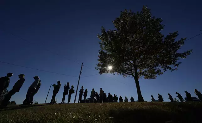 People wait in line to cast their ballots at an early voting location, Thursday, Oct. 31, 2024, in Blue Springs, Mo. (AP Photo/Charlie Riedel)