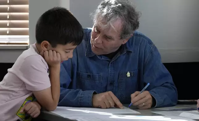 Sen. Sherrod Brown, D-Ohio, fills out his ballot with his grandson, Milo Molina, left, 8, Tuesday, Nov. 5, 2024, in Cleveland. (AP Photo/Sue Ogrocki