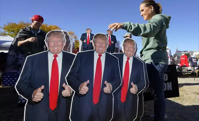 Whitney Bruce of Roanoke, Va., looks at items for sale before Republican presidential nominee former President Donald Trump speaks at a campaign rally in Salem Va., Saturday, Nov 2, 2024. (AP Photo/Steve Helber)