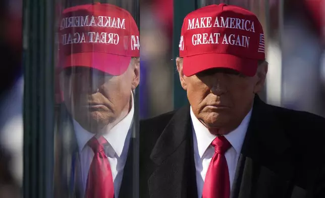 Republican presidential nominee former President Donald Trump is reflected in the bullet proof glass as he finishes speaking at a campaign rally in Lititz, Pa., Sunday, Nov. 3, 2024. (AP Photo/Matt Rourke)