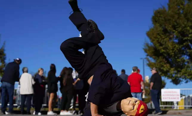 A supporter of Republican presidential nominee former President Donald Trump breakdances outside a campaign rally at Minges Coliseum, Monday, Oct. 21, 2024, in Greenville, N.C. (AP Photo/Julia Demaree Nikhinson)