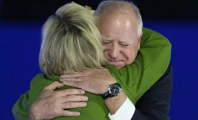 Democratic vice presidential nominee Minnesota Gov. Tim Walz, right, hugs his wife, Gwen Walz, before speaking at a campaign rally, Monday, Nov. 4, 2024, in Detroit. (AP Photo/Charlie Neibergall)