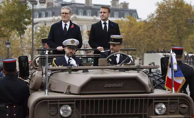 French President Emmanuel Macron, right, and Britain's Prime Minister Keir Starmer review troops aboard a command car during commemorations marking the 106th anniversary of the November 11, 1918, Armistice, ending World War I, at the Arc de Triomphe in Paris, Monday, Nov. 11, 2024. ( Ludovic Marin, Pool via AP)