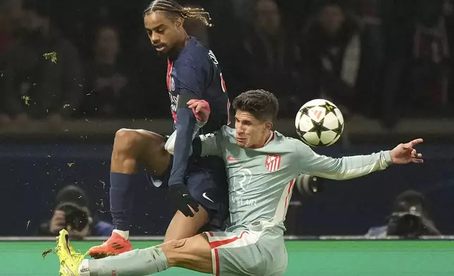 PSG's Bradley Barcola, left, and Atletico Madrid's Giuliano Simeone, right, fight for the ball during the Champions League opening phase soccer match between Paris Saint Germain and Atletico Madrid, at the Parc des Princes stadium, in Paris, Wednesday, Nov. 6, 2024. (AP Photo/Michel Euler)