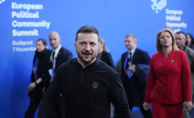 Ukraine's President Volodymyr Zelenskyy, center, and Latvia's Prime Minister Evika Silina, right, arrive for the European Political Community (EPC) Summit at the Puskas Arena in Budapest, Hungary, Thursday, Nov. 7, 2024. (AP Photo/Petr Josek)