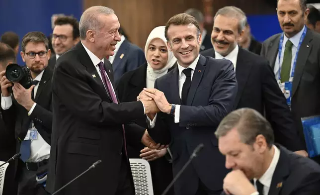 Turkish President Recep Tayyip Erdogan, left, speaks with French President Emmanuel Macron at a plenary session during the European Political Community (EPC) Summit at the Puskas Arena in Budapest, Thursday, Nov. 7, 2024. (AP Photo/Denes Erdos)