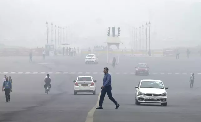 Office-goers walk amidst a dense layer of smog as the air quality index indicates 'severe' category early morning in New Delhi, India, Wednesday, Nov. 13, 2024. (AP Photo)