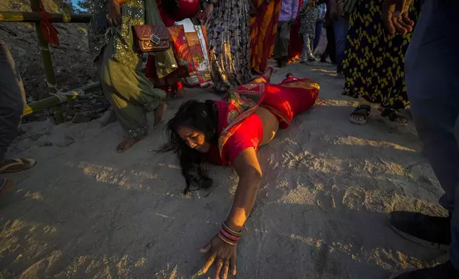 A Hindu devotee moves toward the river Brahmaputra in a prostrate manner to perform rituals during Chhath Puja festival in Guwahati, in the northeastern Indian state of Assam, India, Thursday, Nov. 7, 2024. (AP Photo/Anupam Nath)