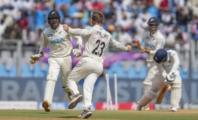 New Zealand's Glenn Phillips, center, celebrates the dismissal of India's Akash Deep during the third day of the third cricket test match between India and New Zealand at Wankhede Stadium, in Mumbai, India, Sunday, Nov. 3, 2024.(AP Photo/Rajanish Kakade)