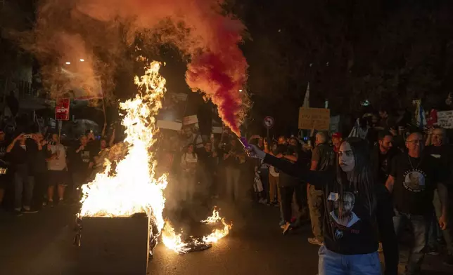 Israelis light a bonfire during a protest against Prime Minister Benjamin Netanyahu near his residence in Jerusalem, a day after he dismissed his defence minister Yoav Gallant, Wednesday, Nov. 6, 2024. (AP Photo/Ohad Zwigenberg)