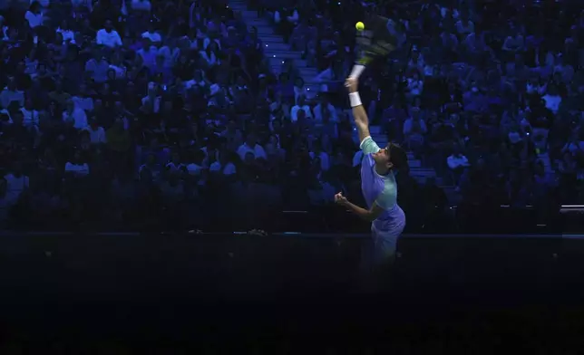 Spain's Carlos Alcaraz returns the ball to Norway's Casper Ruud during their singles tennis match of the ATP World Tour Finals at the Inalpi Arena, in Turin, Italy, Monday, Nov. 11, 2024. (AP Photo/Antonio Calanni)