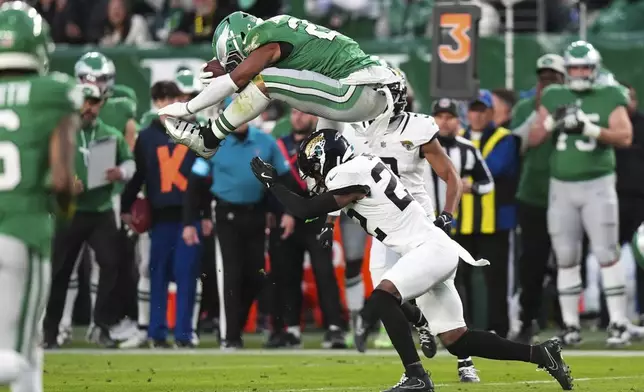 Philadelphia Eagles running back Saquon Barkley (26) hurdles over Jacksonville Jaguars cornerback Jarrian Jones (22) during the first half of an NFL football game Sunday, Nov. 3, 2024, in Philadelphia. (AP Photo/Chris Szagola)