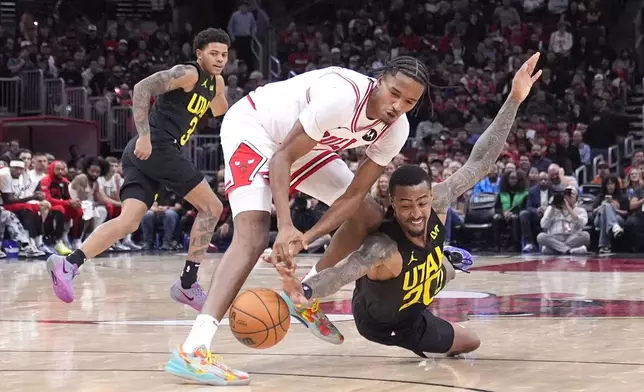 Chicago Bulls' Julian Phillips, left, and Utah Jazz's John Collins battle for a loose ball during the second half of an NBA basketball game Monday, Nov. 4, 2024, in Chicago. (AP Photo/Charles Rex Arbogast)