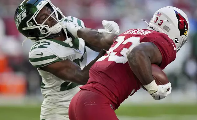 Arizona Cardinals running back Trey Benson (33) stiff arms New York Jets safety Tony Adams (22) during the second half of an NFL football game, Sunday, Nov. 10, 2024, in Glendale, Ariz. (AP Photo/Brynn Anderson)