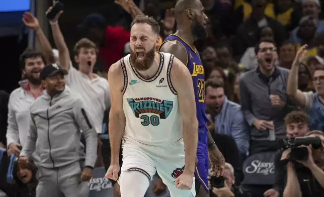 Memphis Grizzlies center Jay Huff (30) reacts after scoring as Los Angeles Lakers forward LeBron James (23) looks on during in the second half of an NBA basketball game Wednesday, Nov. 6, 2024, in Memphis, Tenn. (AP Photo/Nikki Boertman)