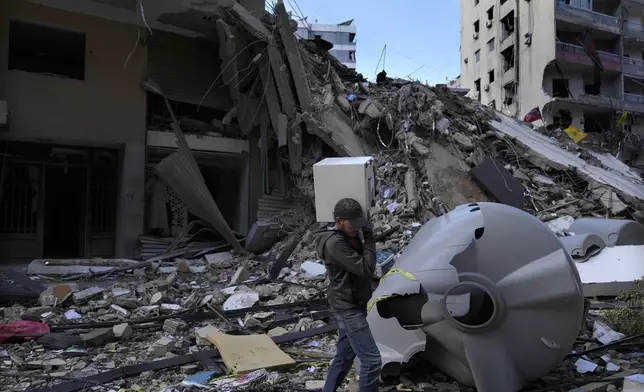 A man carries a safe box after he pulls it out of a destroyed building that was hit by an Israeli airstrike in Dahiyeh, in the southern suburb of Beirut, Lebanon, Monday, Nov. 11, 2024. (AP Photo/Hussein Malla)