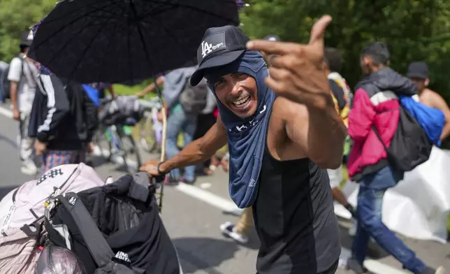 Venezuelan migrant Jonathan Morales Aguilar appeals for humanitarian aid for people of a migrant caravan walking along the Huixtla highway, in southern Mexico, Wednesday, Nov. 6, 2024, hoping to reach the country's northern border and ultimately the United States. (AP Photo/Moises Castillo)