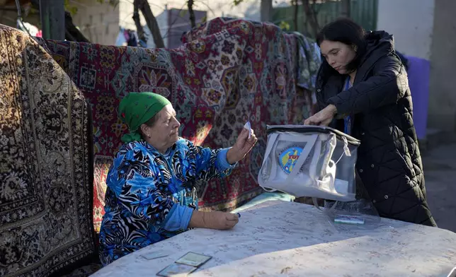 A woman casts her vote in a mobile ballot box during a presidential election runoff, in the village of Ciopleni, Moldova, Sunday, Nov. 3, 2024. (AP Photo/Vadim Ghirda)