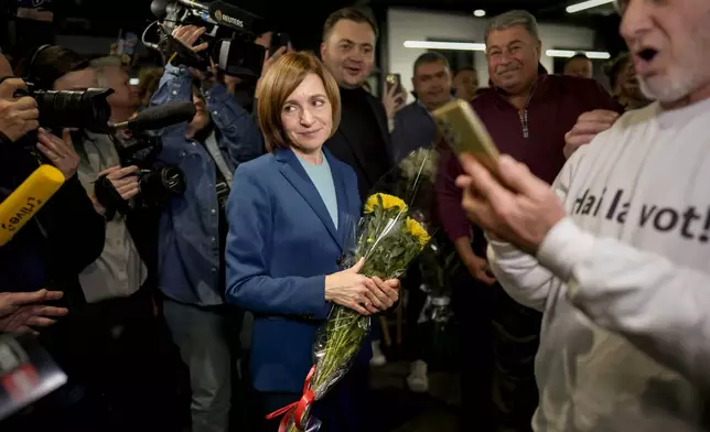 Moldova's President Maia Sandu celebrates with supporters as preliminary results are announced for the presidential election runoff in Chisinau, Moldova, Sunday, Nov. 3, 2024. (AP Photo/Vadim Ghirda)