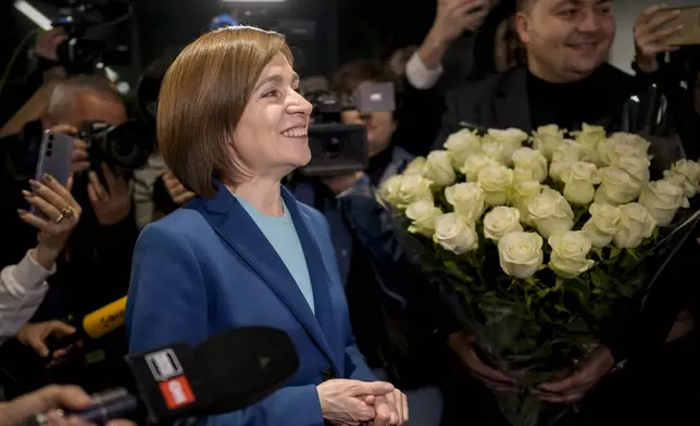 Moldova's President Maia Sandu celebrates with supporters as preliminary results are announced for the presidential election runoff in Chisinau, Moldova, Sunday, Nov. 3, 2024. (AP Photo/Vadim Ghirda)